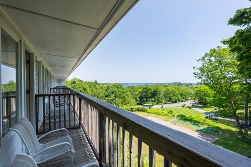 a balcony with a bench and a view of a park at Wonder View Inn in Bar Harbor