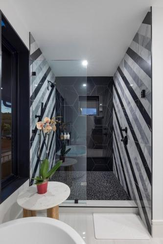 a bathroom with a shower with a toilet and a table at Hale O Ka Nene in Koloa