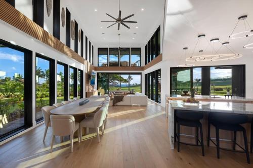 a dining room and living room with a table and chairs at Hale O Ka Nene in Koloa