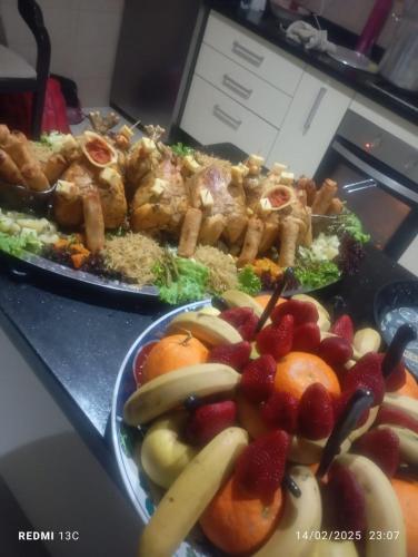 two plates of food on a table with fruits and vegetables at Lina Village in Al Hachlaf