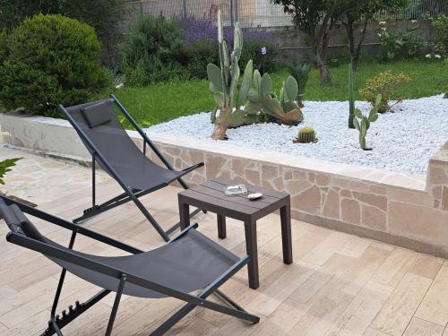 two chairs and a table in a garden at Il Boschetto in Santo Spirito