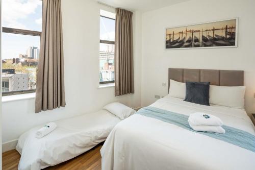 a bedroom with two beds and two windows at London City Hotel in Woolwich