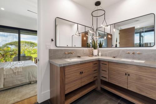 a bathroom with two sinks and a large mirror at Hale O Ka Nene in Koloa