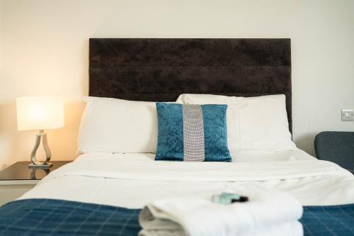 a bedroom with a bed with blue and white pillows at London City Hotel in Woolwich