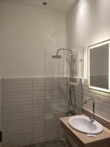 a bathroom with a sink and a glass shower at Talaat Harb Hotel in Cairo