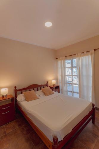 a bedroom with a large bed and a window at Cabañas La Fortaleza in La Caldera
