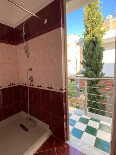 a bathroom with a shower with a tile floor at Guest House Twins in Durrës