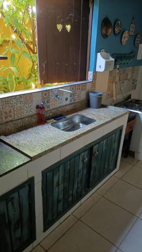 a kitchen counter with a sink and a window at VILLA COIMBRA in Lauro de Freitas