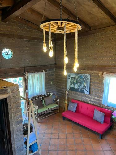a living room with a red couch and two chairs at Cabañas el lago in Zacatlán