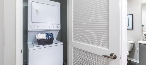 北好莱坞Noho Haven 2 bed Apt with FREE Parking的门旁边有洗衣机和烘干机的浴室