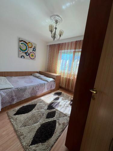a bedroom with a bed and a rug on the floor at Florence apartament in Constanţa