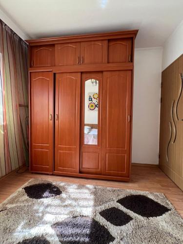 a room with a large wooden cabinet and a rug at Florence apartament in Constanţa