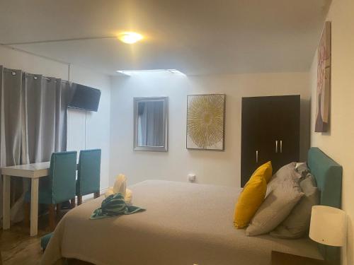 une chambre avec un lit, des chaises et une table dans l'établissement Home estudio 5, à Santiago