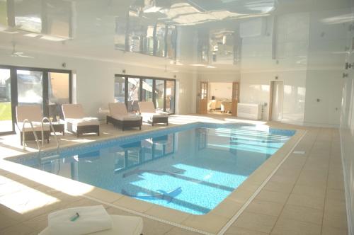 a large swimming pool in a large room with at Woodhouse Farm Lodge in Spalding