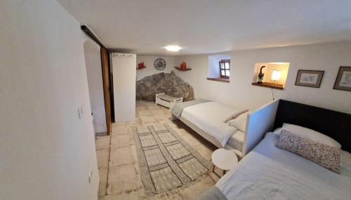 a bedroom with two beds and a rock wall at Apartma Pri Lukšu in Tolmin