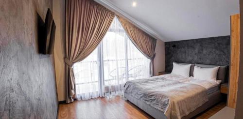 a bedroom with a bed and a large window at Chalet 348 in Palyanytsya