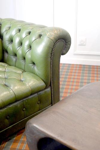 a green leather couch sitting in a living room at LeCapitaine-LeParticulier Collection in Chartres