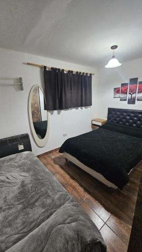 a bedroom with a bed and a mirror at Caleta Olivia Ancla alojamiento departamento in Caleta Olivia