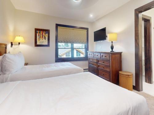 a bedroom with two beds and a dresser and a window at Montaneros in Vail in Vail