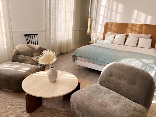 ein Schlafzimmer mit einem Bett und einem Tisch und Stühlen in der Unterkunft Charme, lumiere, jardin et sauna! in Étretat