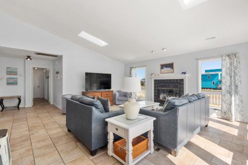 a living room with two couches and a fireplace at Wishing Whale in Corolla