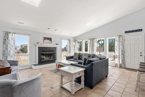 a living room with a couch and a fireplace at Wishing Whale in Corolla