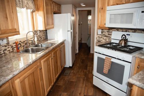 a kitchen with a sink and a stove top oven at Canyonlands Cabin #19 in Moab