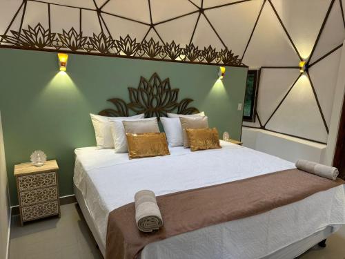 a bedroom with a large bed with white sheets and gold pillows at Finca Brisas de la Montaña in Coco
