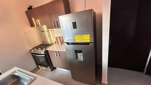 a kitchen with a stainless steel refrigerator and a stove at Sunset Haven Beach House in Palo Verde