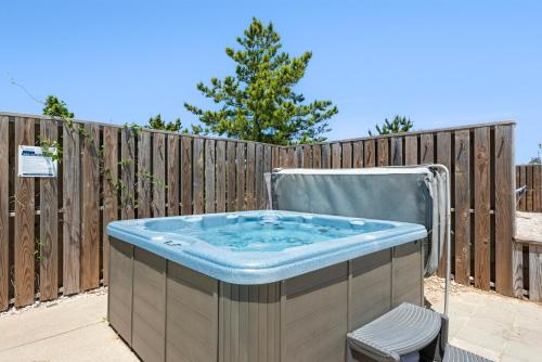 a hot tub in a backyard next to a wooden fence at Marlin Manor by Village Realty in Nags Head