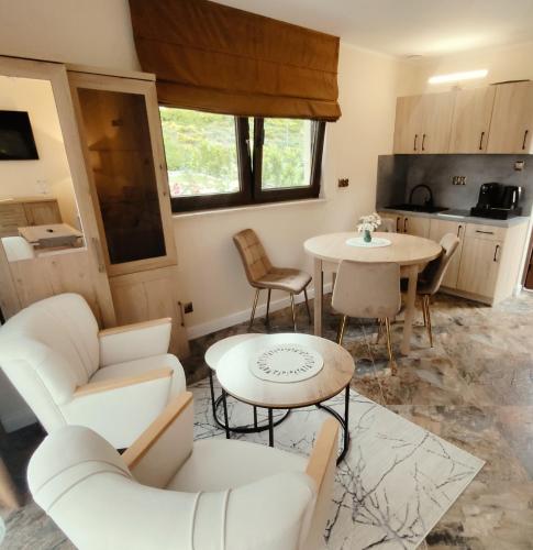a living room with white furniture and a table at Osada Prado in Michałkowa
