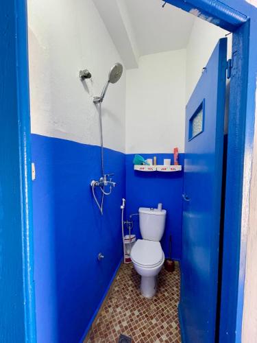 a blue bathroom with a toilet and a shower at Casa bleuté in Asilah