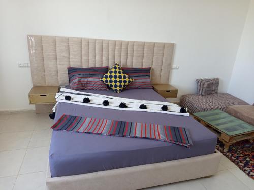 a bed with two pillows on it in a room at Lina Village in Al Hachlaf