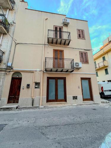 a building with windows and balconies on a street at Casa Vacanza Acquanuova in Calatafimi