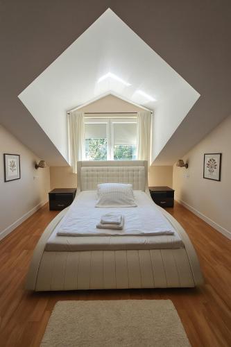 a large white bed in a room with a window at Dworek Różany Hotel & Restauracja in Namysłów