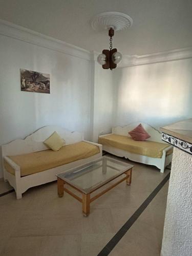 ハンマメットにあるappartement 3 pieces Hammamet centreのリビングルーム(ベッド2台、コーヒーテーブル付)