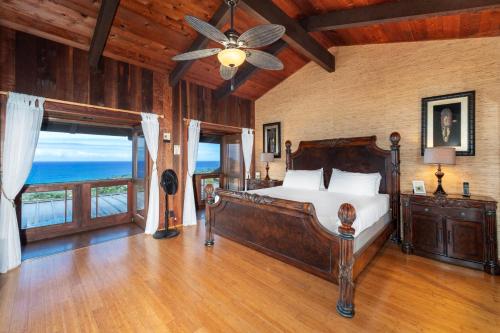 Un dormitorio con una cama y un ventilador de techo. en Ailina House, en Kailua-Kona
