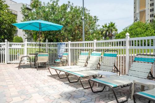 a group of chairs and an umbrella on a patio at Emerald Luxe Lakeview 6 min to EPIC Universe in Orlando