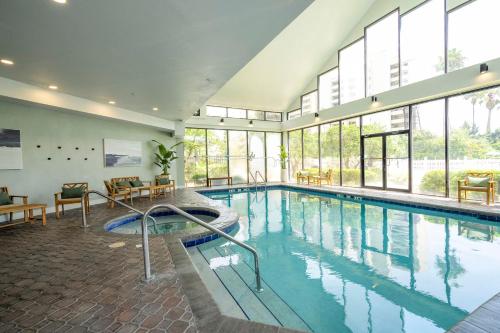 a large swimming pool in a building with windows at Emerald Luxe Lakeview 6 min to EPIC Universe in Orlando