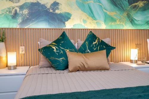 a bed with four pillows on it with two lamps at Emerald Luxe Lakeview 6 min to EPIC Universe in Orlando