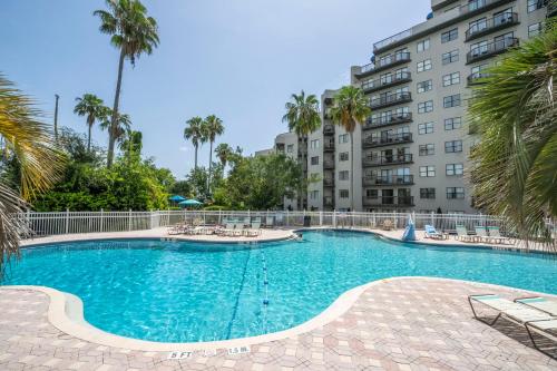 a swimming pool in front of a building with palm trees at Emerald Luxe Lakeview 6 min to EPIC Universe in Orlando