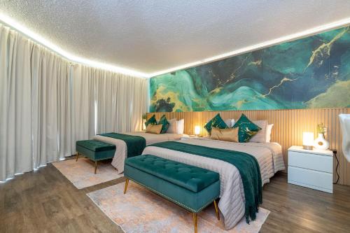 a bedroom with two beds and a painting on the wall at Emerald Luxe Lakeview 6 min to EPIC Universe in Orlando