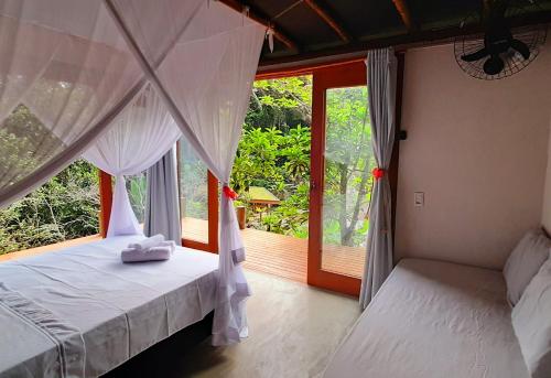 a bedroom with two beds and a window at Bangalô do Pôr do Sol Moreré in Moreré