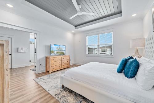 ペンサコーラにあるCoastal Soulの白いベッドルーム(ベッド1台、テレビ付)