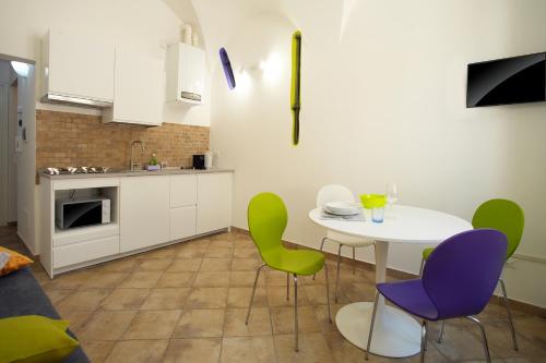 a kitchen with a white table and green chairs at navone10 in Albenga
