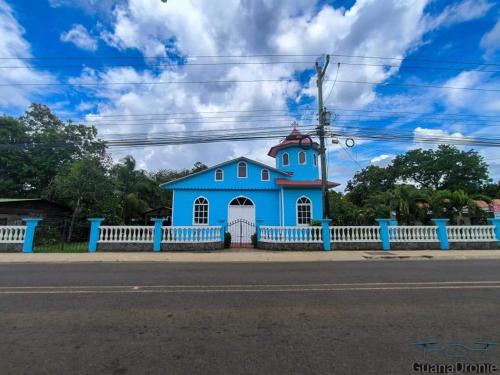 a blue building on the side of the road at Casa Abierta Playa Juquillal 1 habitacion in Santa Cruz