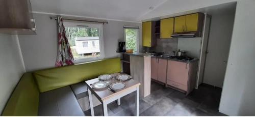 una piccola cucina con tavolo e ciotole di Bungalow confortable à Saint-Chéron avec piscine a Saint-Chéron