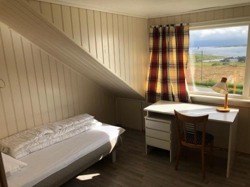 a bedroom with a bed and a desk and a window at Two floors house with 3 bed rooms and room for 8 persons in Ålesund