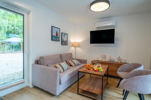 a living room with a couch and a table at Baltic Forest in Kołobrzeg