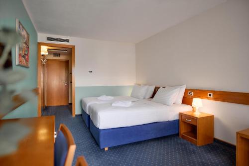 a hotel room with a bed and a table at Hotel Selce in Selce